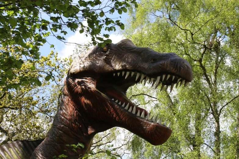 an life size dinosaur statue that appears to have it's teeth missing