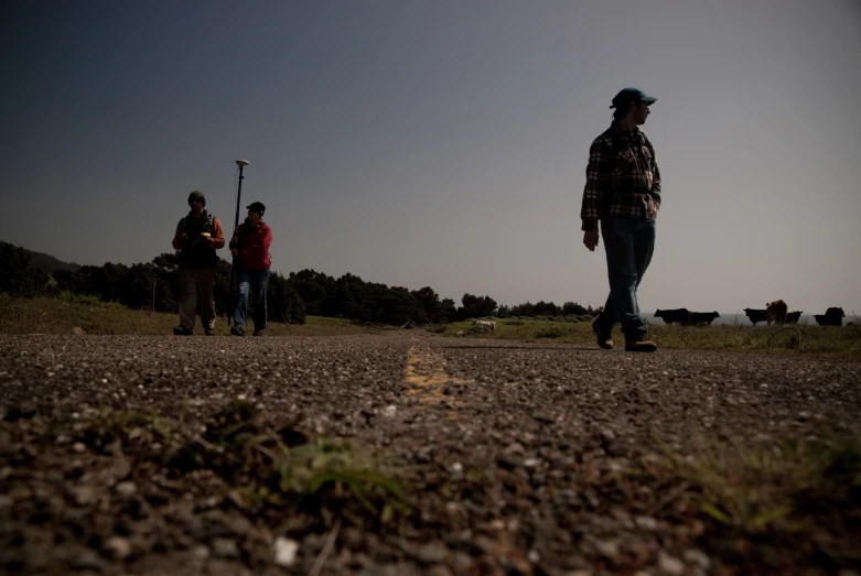 two men walking down the road with their gear in hand