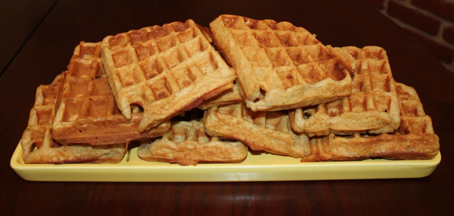 a plate of waffles sitting on top of a wooden table