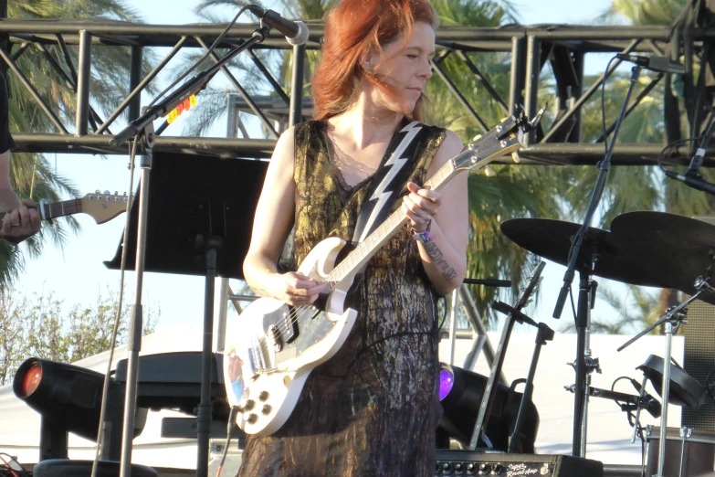 a woman playing an electric guitar on stage