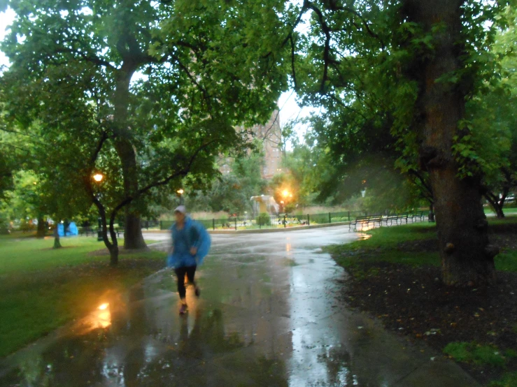 a man walking in the rain with a blue jacket on