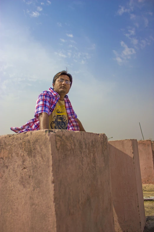 the boy poses on top of some cinder blocks