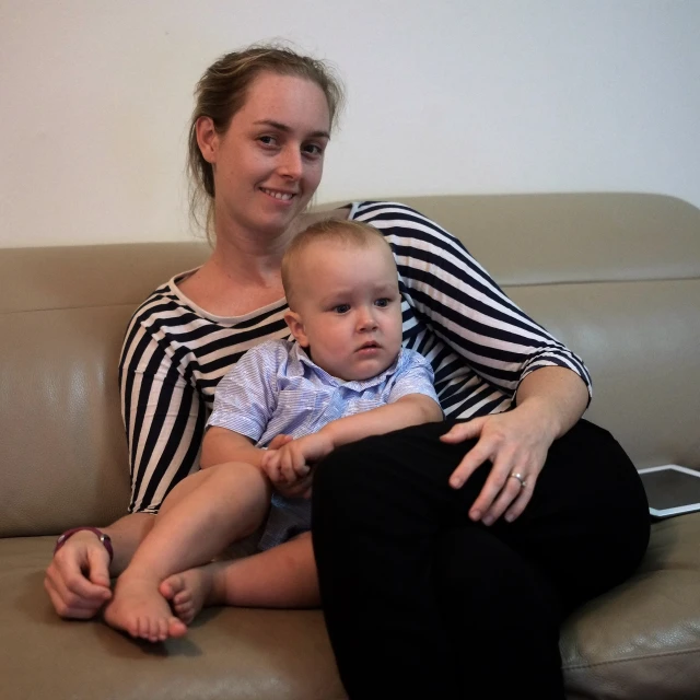 a mother and her baby sitting on a couch