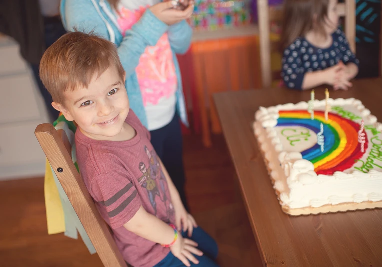 two children sitting at a table with some birthday cake