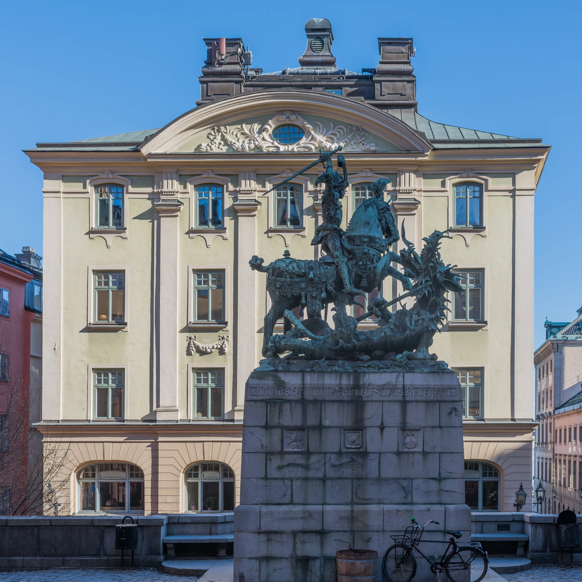 a statue of a man with a horse in front of a building