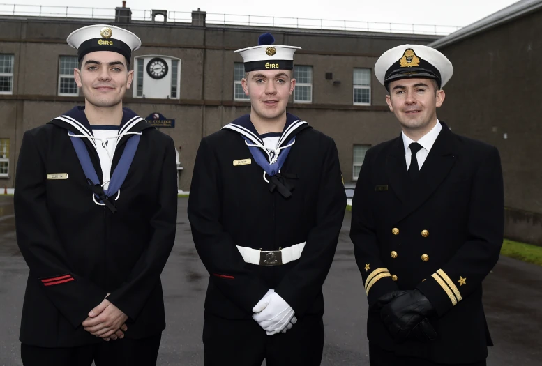 three young sailors in uniform posing for a po