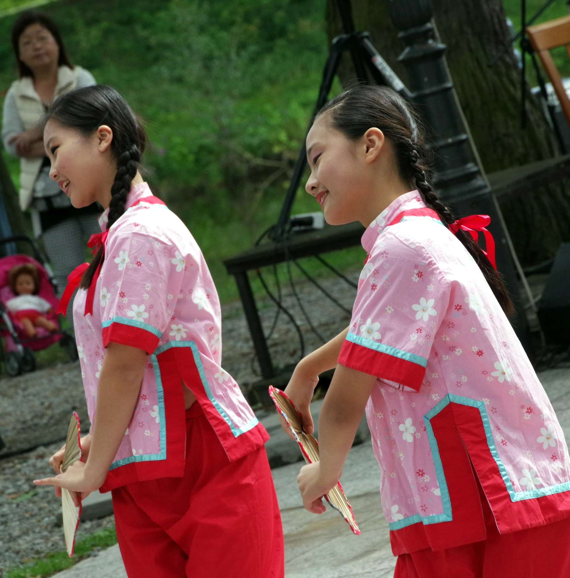 two s dressed in red dress and holding items