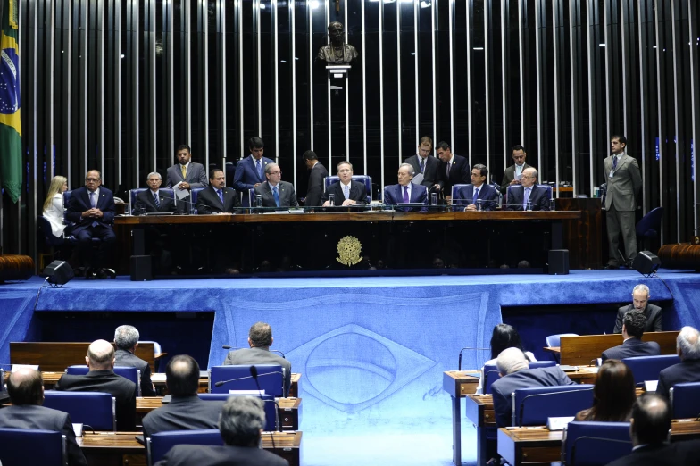 a group of people sit and wait for a public meeting