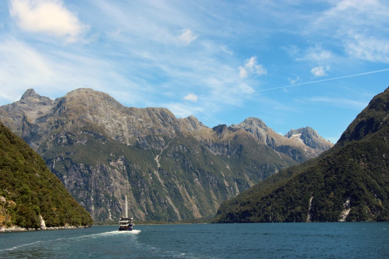 boat with mountains in background passing through water