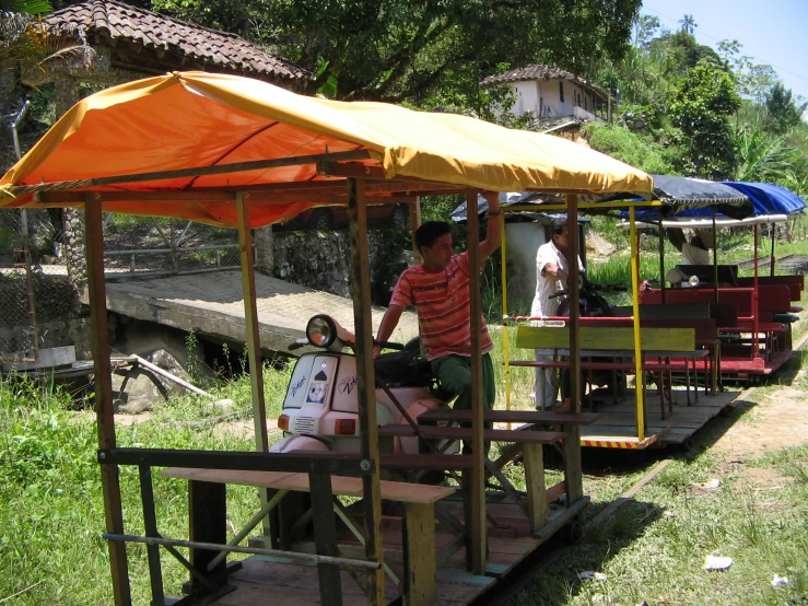 a yellow umbrella sits over a red trolley