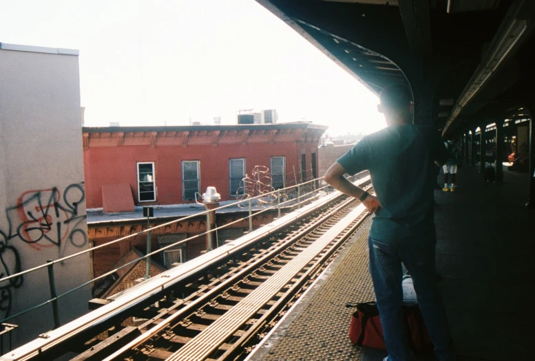 a man standing on a platform next to train tracks