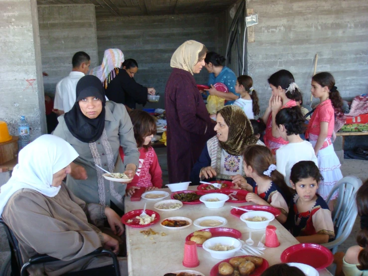 a group of women stand around a table full of food