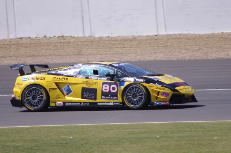 a car drives on a racing track next to grass