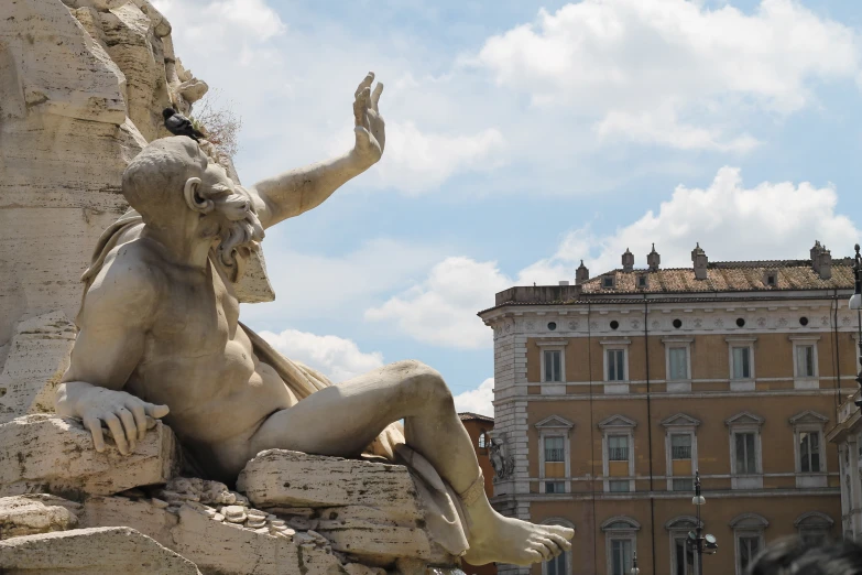 the statue of a man is near some buildings