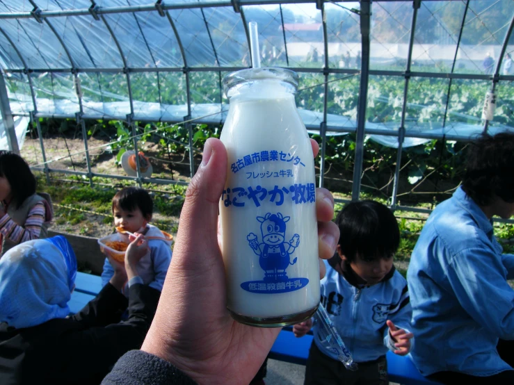 a bottle of milk is being held in front of young children