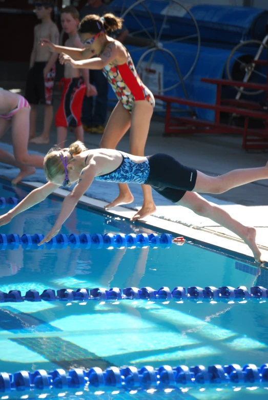 two children are diving into the swimming pool