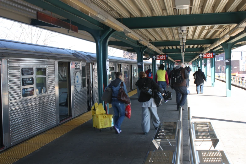 a train station with passengers walking out and into it