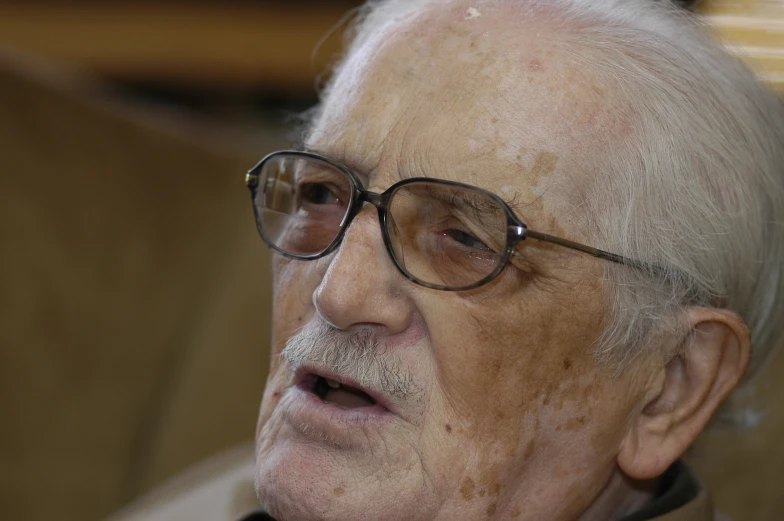 a man with glasses looking away from the camera