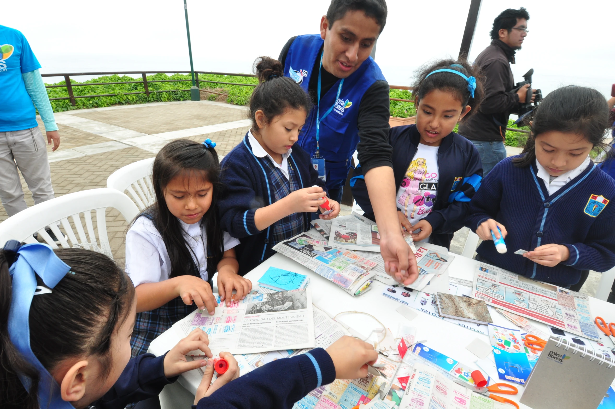 a group of young children around a table working on projects