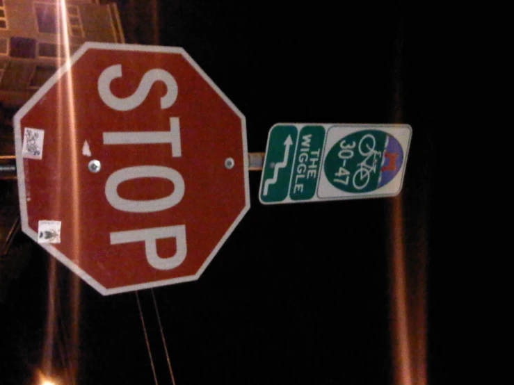 stop sign with the green and white stickers attached to it