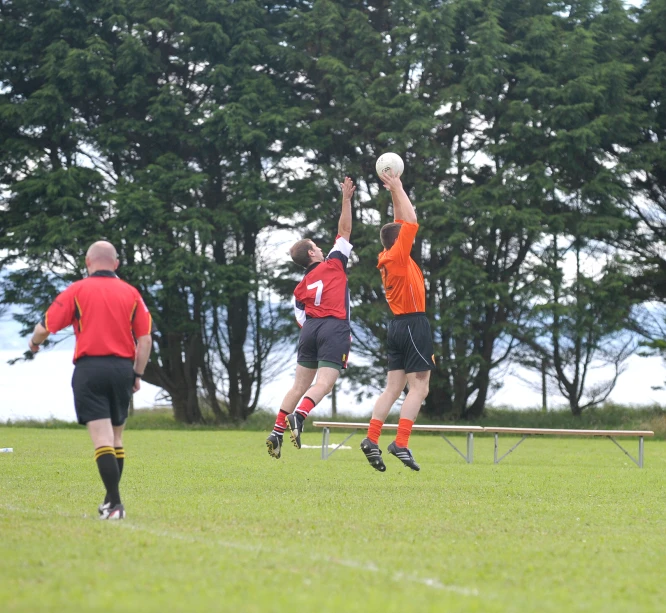 the two men are trying to get up for a flying ball