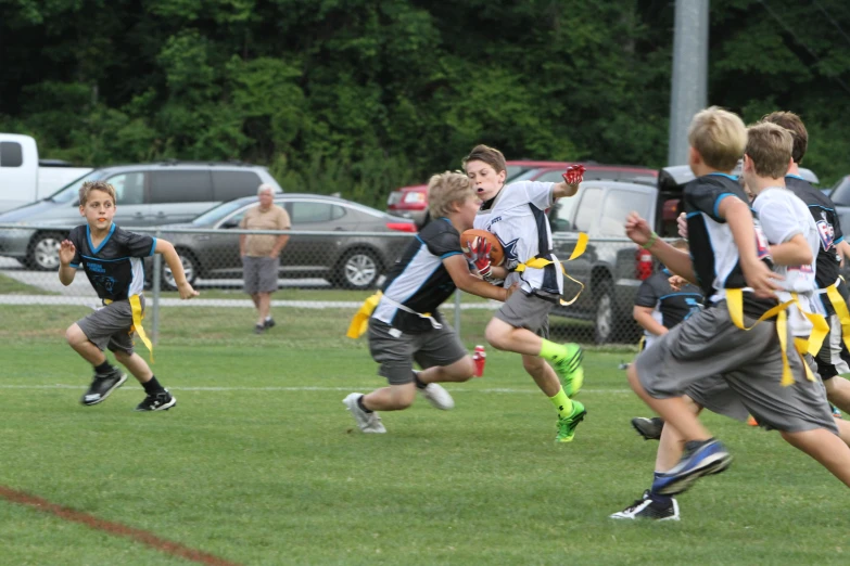 a group of children running towards a ball with helmets on