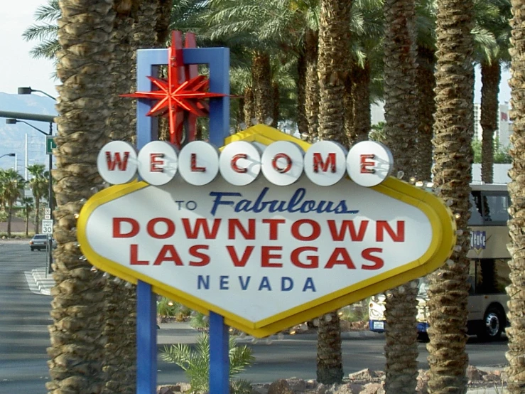 a sign for downtown las vegas with palm trees around it