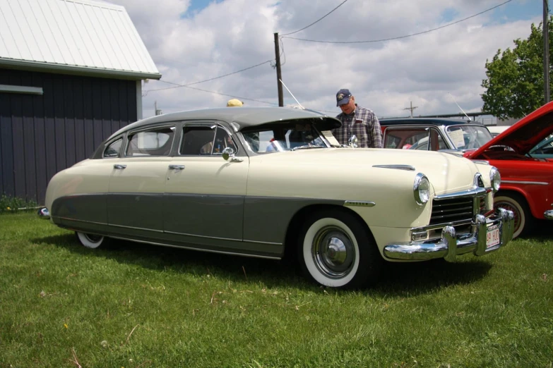 a old car and other antique cars parked in the grass