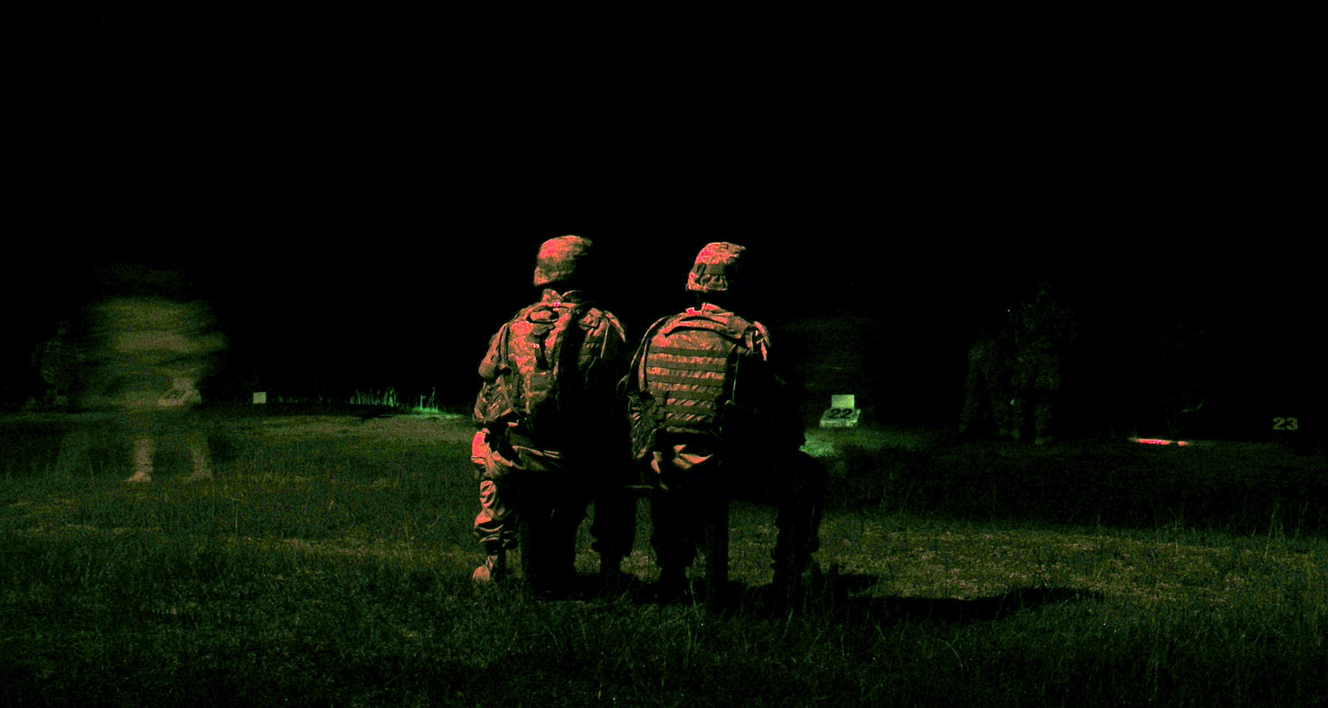 a couple of men standing on top of a grass covered field