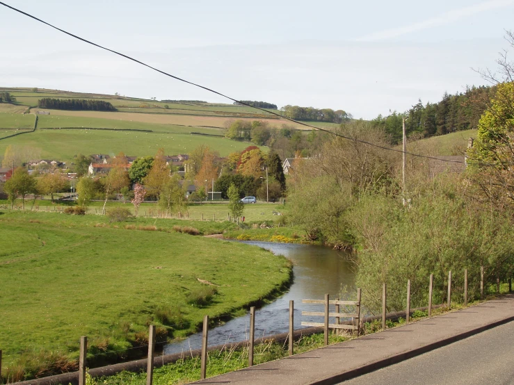 the winding road runs along the banks of a stream