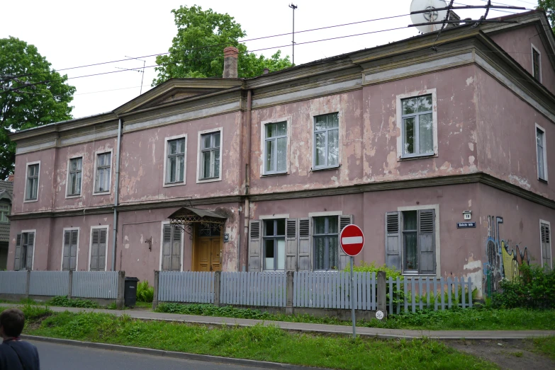 an old building is pink and white on the corner