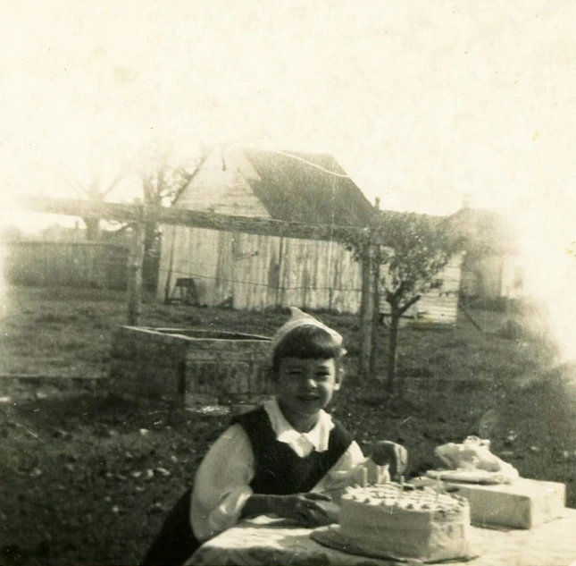 old fashioned pograph of a person at a table with a cake