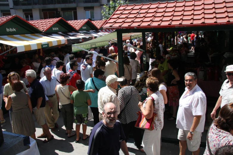 a crowd of people are standing in an area with some stores