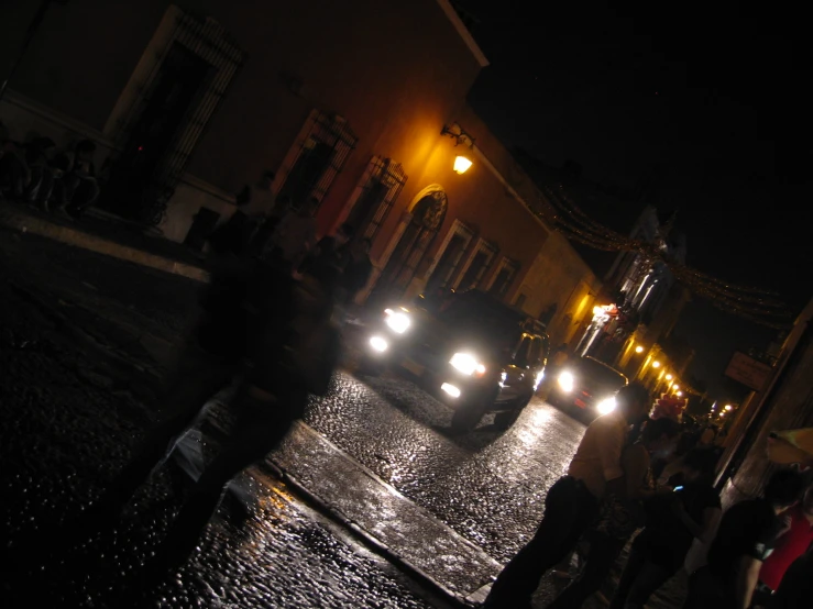 the night time image of people crossing the street at an intersection