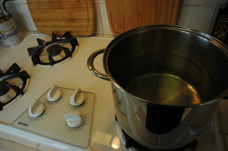 a saucepan and three pepper shakers on top of a stove