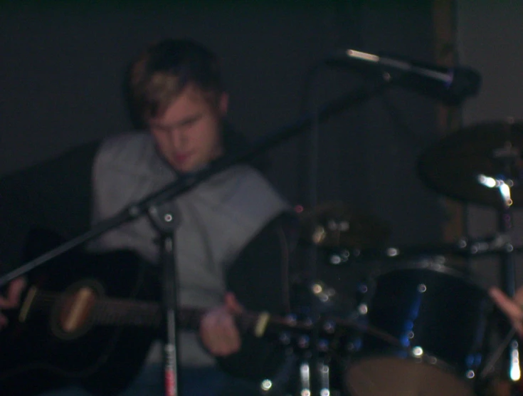 two men are playing guitars in a recording studio