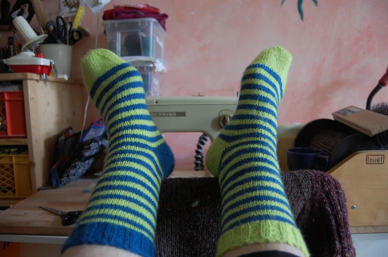 feet up in striped socks sewing on the table