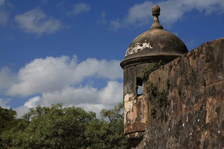 a round old structure with a domed top against a cloudy sky