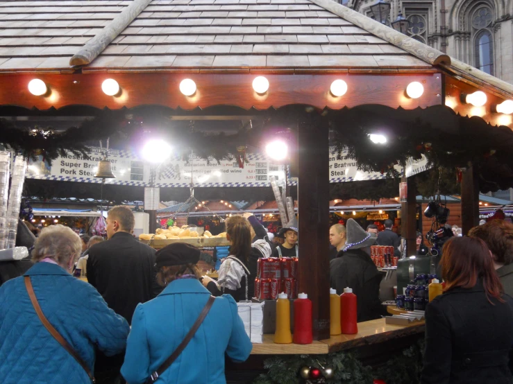 people standing in front of a stall with candles