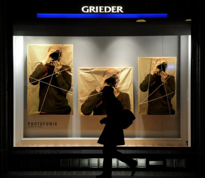 a woman taking a picture in front of a store window