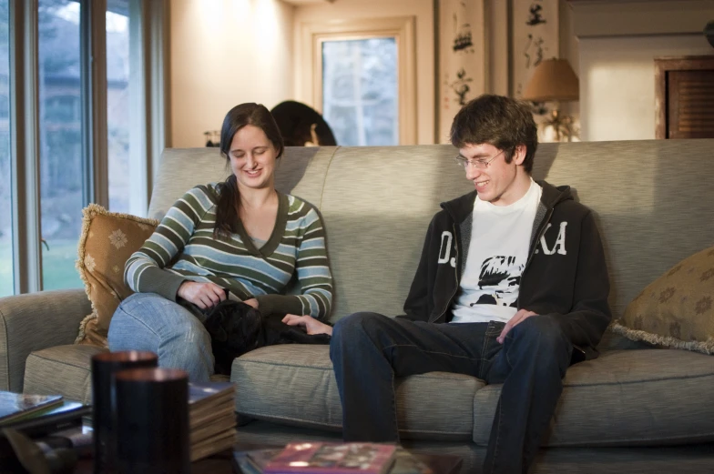 a man and woman sitting on the couch in a living room