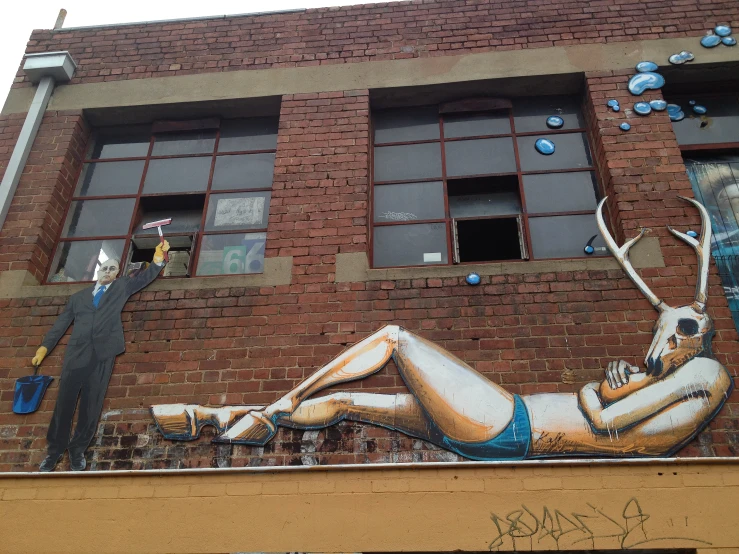 a man waving from his window with some graffiti on the side