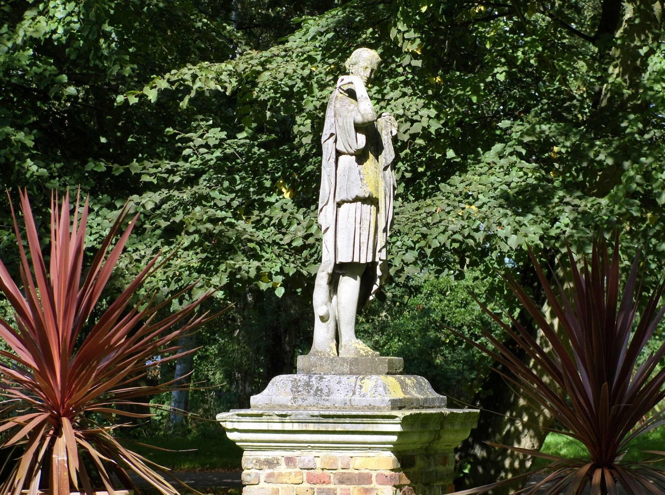 a statue that is sitting next to trees