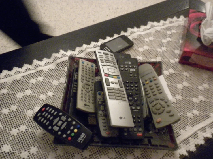 a pile of remote controls sitting on top of a table