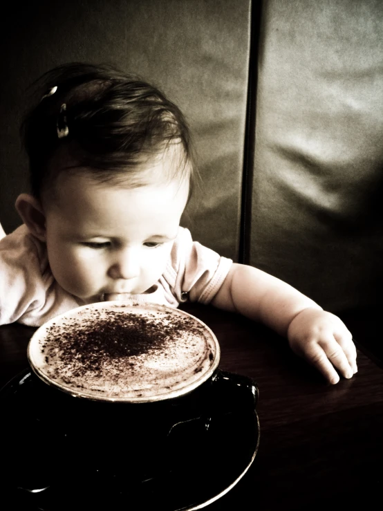 a small girl holding up a large piece of cake