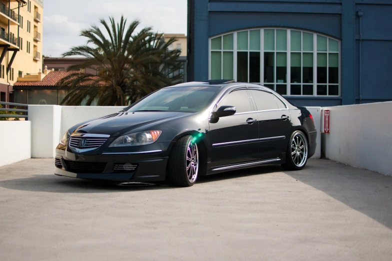 a black car with green lights parked next to a wall