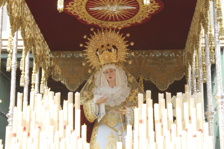 a woman wearing an elaborate outfit in front of candles