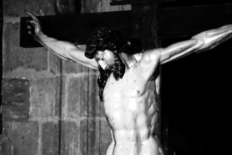 a man with long hair is standing in front of a cross