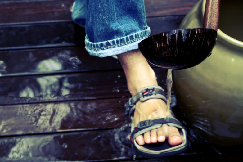 the feet of a person in sandals standing at a door