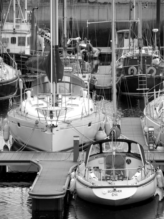 several sail boats are docked in the water